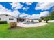 Backyard view of pool area, deck, and white house with green lawn at 275 Tollgate Trl, Longwood, FL 32750