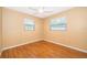 Bedroom with hardwood floors, ceiling fan, and natural light from two windows at 275 Tollgate Trl, Longwood, FL 32750