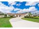 Inviting single-story home featuring a circular driveway and well-maintained landscaping, including lush green grass and shrubbery at 275 Tollgate Trl, Longwood, FL 32750