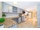 Contemporary kitchen featuring sleek gray cabinets, granite countertops, modern appliances, and tiled floors for easy maintenance at 275 Tollgate Trl, Longwood, FL 32750