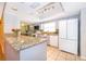 Well-lit kitchen with gray cabinets, granite counters, tile flooring, and modern appliances, offering a blend of style and function at 275 Tollgate Trl, Longwood, FL 32750