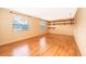 Bright living room featuring laminate flooring, two windows providing natural light, and stylish shelving for decor or storage at 275 Tollgate Trl, Longwood, FL 32750