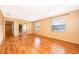 Spacious living room features laminate wood flooring, large windows, and an open doorway to the kitchen and dining areas at 275 Tollgate Trl, Longwood, FL 32750