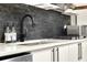 Close up of the kitchen with stainless steel appliances, sleek black faucet, and gray stacked stone backsplash at 2811 Citron Dr, Longwood, FL 32779