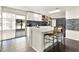 Bright kitchen with modern white cabinets, island, breakfast bar, and sliding glass door to the patio at 2811 Citron Dr, Longwood, FL 32779