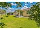 Expansive backyard with a covered patio, green lawn, and views of neighboring homes and lush trees at 2815 Shelburne Way, St Cloud, FL 34772