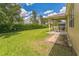 Spacious backyard featuring lush lawn, mature trees, and covered patio, perfect for outdoor enjoyment and relaxation at 2815 Shelburne Way, St Cloud, FL 34772