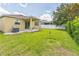 Lush backyard with a covered patio, green lawn, privacy fence, and ample space for outdoor activities at 2815 Shelburne Way, St Cloud, FL 34772