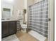 Well-lit bathroom featuring a vanity, toilet, decorative towels and a shower with gray and white striped curtain at 2815 Shelburne Way, St Cloud, FL 34772