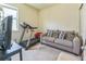 Cozy bedroom featuring a comfortable sofa and treadmill, perfect for relaxation and exercise at 2815 Shelburne Way, St Cloud, FL 34772