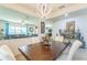 Open concept dining area with modern chandelier and views of the living room at 2815 Shelburne Way, St Cloud, FL 34772
