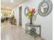 Inviting hallway with tile flooring, decorative mirrors, and a glass console table with floral arrangement at 2815 Shelburne Way, St Cloud, FL 34772