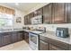 Efficient kitchen design with stainless steel appliances, dark cabinetry, and granite countertops at 2815 Shelburne Way, St Cloud, FL 34772