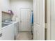 Laundry room with a washing machine, dryer, a storage shelf, and a view of an adjacent hallway at 2815 Shelburne Way, St Cloud, FL 34772