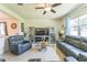 Spacious living room with plush leather seating, ceiling fan, and large windows offering natural light at 2815 Shelburne Way, St Cloud, FL 34772