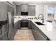 Contemporary kitchen featuring stainless steel appliances, quartz countertops, and stylish gray cabinetry at 2823 Camellia Flower St, Apopka, FL 32703