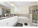 Bright bathroom features dual sinks, soaking tub, and walk-in glass shower at 2919 Verse St, Kissimmee, FL 34746