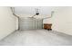 Spacious two-car garage featuring a metal door, trash receptacles, and concrete flooring at 2919 Verse St, Kissimmee, FL 34746