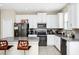 Modern kitchen features white cabinets, stainless steel appliances, and an island with barstool seating at 2919 Verse St, Kissimmee, FL 34746