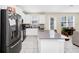 Modern kitchen boasts white cabinetry, a large center island, stainless steel appliances, and a seamless connection to the living area at 2919 Verse St, Kissimmee, FL 34746
