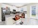 Modern kitchen features white cabinetry, a center island with bar seating, and stainless steel appliances at 2919 Verse St, Kissimmee, FL 34746