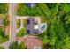 Stunning aerial view of a home with solar panels and a kidney-shaped pool surrounded by lush greenery at 3011 Temple Trl, Winter Park, FL 32789