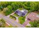 Beautiful aerial perspective of the home and driveway lined by green foliage and solar panels at 3011 Temple Trl, Winter Park, FL 32789