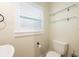 Clean bathroom featuring a toilet, sink, and window with shelves at 3011 Temple Trl, Winter Park, FL 32789