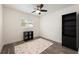 Minimalist bedroom with hardwood floors, ceiling fan, and a fun rug near a bookshelf at 3011 Temple Trl, Winter Park, FL 32789