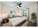 Cozy bedroom with a ceiling fan, hardwood floors, and natural light streaming through the windows at 3011 Temple Trl, Winter Park, FL 32789