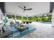 Relaxing outdoor patio features comfortable seating, ceiling fans, and views of the pool and lush backyard at 3011 Temple Trl, Winter Park, FL 32789