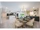 Open dining area with stylish chandelier, bar, and access to a modern kitchen and outdoor views at 3011 Temple Trl, Winter Park, FL 32789