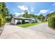 A charming exterior view of the home showcasing its paved driveway and manicured lawn at 3011 Temple Trl, Winter Park, FL 32789