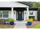 Welcoming front door entrance with sidelights, potted plants, and well-maintained landscaping at 3011 Temple Trl, Winter Park, FL 32789