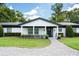 Charming single-story home with white siding, black trim, manicured landscaping, and a welcoming entryway at 3011 Temple Trl, Winter Park, FL 32789