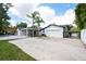 View of the home's 2-car garage and adjoining outdoor living space with stone flooring at 3011 Temple Trl, Winter Park, FL 32789