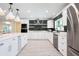 Bright kitchen with white cabinetry, stainless steel appliances, a stylish backsplash, and wood-look floors at 3011 Temple Trl, Winter Park, FL 32789