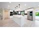 Modern kitchen featuring a spacious island, stainless steel appliances, white cabinetry, and sleek countertops at 3011 Temple Trl, Winter Park, FL 32789