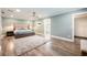 Comfortable main bedroom with a large bed, soft lighting, hardwood floors, and access to an ensuite bathroom at 3011 Temple Trl, Winter Park, FL 32789