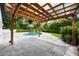 Backyard featuring a pool with a wooden pergola and lush landscaping at 3011 Temple Trl, Winter Park, FL 32789