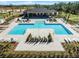 Aerial view of community pool with a clubhouse and lounge chairs, all surrounded by lush landscaping at 3310 Arch Ave, Ormond Beach, FL 32174