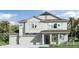 An attractive two-story home features a two-car garage and welcoming facade and is surrounded by mature landscaping at 3310 Arch Ave, Ormond Beach, FL 32174