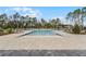 Community pool with a large deck surrounded by green space and lounge chairs, perfect for relaxing and soaking up the sun at 3310 Arch Ave, Ormond Beach, FL 32174