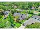 Aerial view shows a home with a large yard, mature trees, and a nearby neighborhood pool at 370 Brushwood Ln, Winter Springs, FL 32708