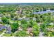 Aerial view of a neighborhood with homes nestled among trees, some featuring private pools and lake views at 370 Brushwood Ln, Winter Springs, FL 32708