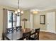 Inviting dining room with a wooden table, elegant chandelier, and large window with natural light at 370 Brushwood Ln, Winter Springs, FL 32708