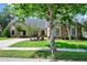 Charming brick home with mature trees, well-maintained lawn, and a long driveway leading to the garage at 370 Brushwood Ln, Winter Springs, FL 32708
