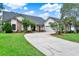Charming single Gathering home featuring a brick facade, manicured lawn, and a long driveway at 370 Brushwood Ln, Winter Springs, FL 32708