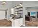Bright, modern kitchen features floating shelves, an eat-in bar, and access to the living area at 370 Brushwood Ln, Winter Springs, FL 32708