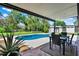 Private backyard oasis featuring a sparkling in-ground pool, lush landscaping, and a covered patio at 370 Brushwood Ln, Winter Springs, FL 32708
